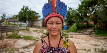 Women in a traditional, colorful headpiece smiles softly at the camera.