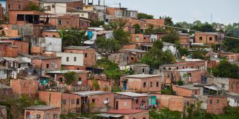 A faraway shot of an informal settlement, with brown shacks and spots of color.