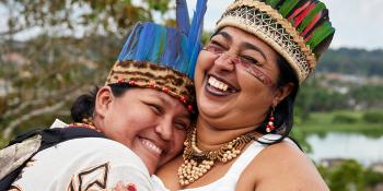 Two women in traditional clothing hugging.