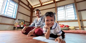 Parent and child smiling at the camera in a large room.