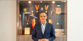 Un hombre frente a una vitrina de trofeos