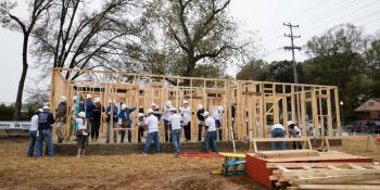 Volunteers raising a wall frame together on a build site at 2016 Carter Work Project in Memphis.