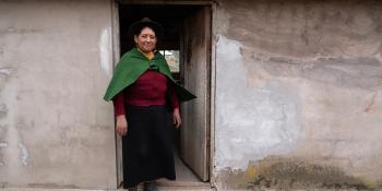 A woman standing in the doorway of her home.
