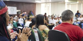 Brazilian woman in traditional headdress attends a community meeting