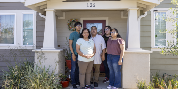 Family standing in front of house.