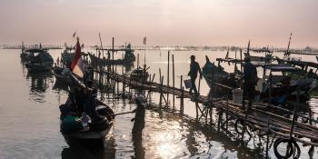 Fishermen head out to their boats in the early morning light.