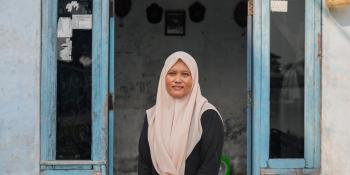 Woman in hijab standing in the doorway of her rental home.