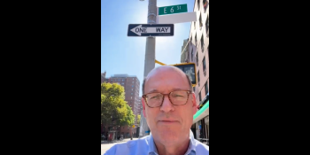 Jonathan Reckford selfie shot in front of 6th Street sign in New York City.