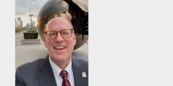 Selfie video still of Jonathan Reckford standing in front of United Nations sphere sculpture.