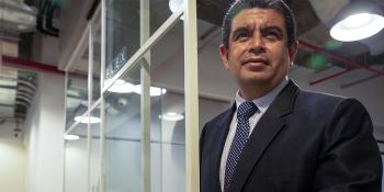A man wearing a suit stands in a doorway