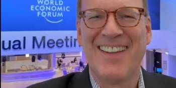 Jonathan Reckford taking selfie with WEF sign in background.