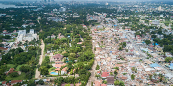 An aerial view of a cityscape full of homes, office buildings, and trees.