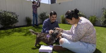  The Chavez family hang out with their dog Scruffy in the common area of the community where they live. 