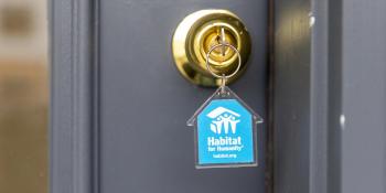 key in lock with blue house-shaped Habitat keychain.