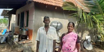 Couple standing in front of home