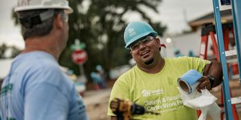 Benito laughs with Carter Work project volunteer on a build site