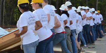 Group of Bank of America volunteers raising a wall on Habitat build site.