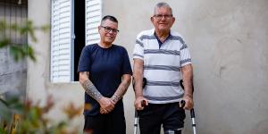 Kinha and his father outside their new home.