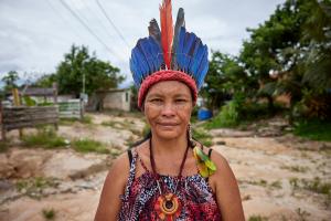 Women in a traditional, colorful headpiece smiles softly at the camera.