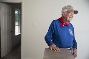 A smiling President Carter standing in a Habitat house