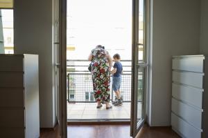 woman and child looking out on the balcony
