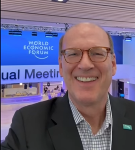 Jonathan Reckford taking selfie with WEF sign in background.