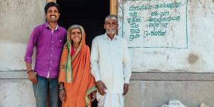 Smiling homeowners standing by doorway