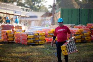 Volunteer carrying ladder.