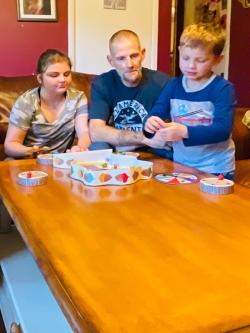 Father playing a board game with two kids in their home.
