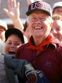 Close up of President Carter smiling amongst a crowd of volunteers