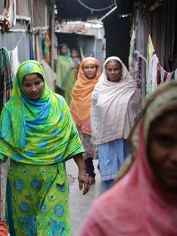 Women walking through Duaripara informal settlement in Dhaka Bangladesh