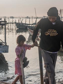 In Tanjung Kait village, Indonesia, Akmadi's daughter greets him after he returned from fishing.