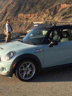 Light blue mini cooper on an ocean overlook.