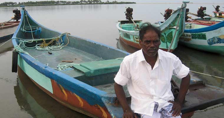 G. Sundaramurthy leaning on his fishing boat