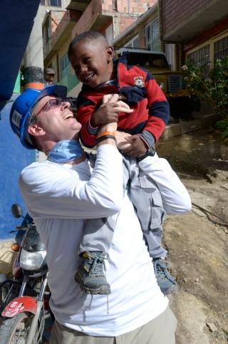 Jonathan Reckford holds a laughing child in Colombia