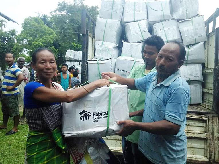 A flood survivor in Assam, India, receiving an emergency kit