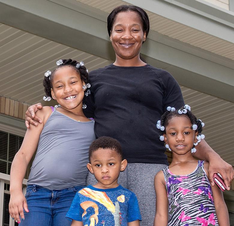 Lanay and her children stand on the porch of their Habitat house in Ohio.