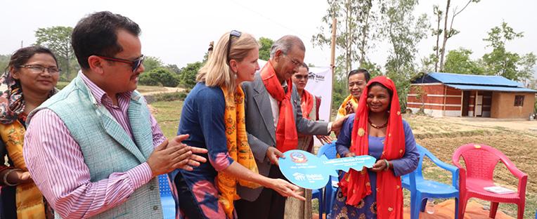 Chameli (far right) receives a symbolic key at the handover of her house