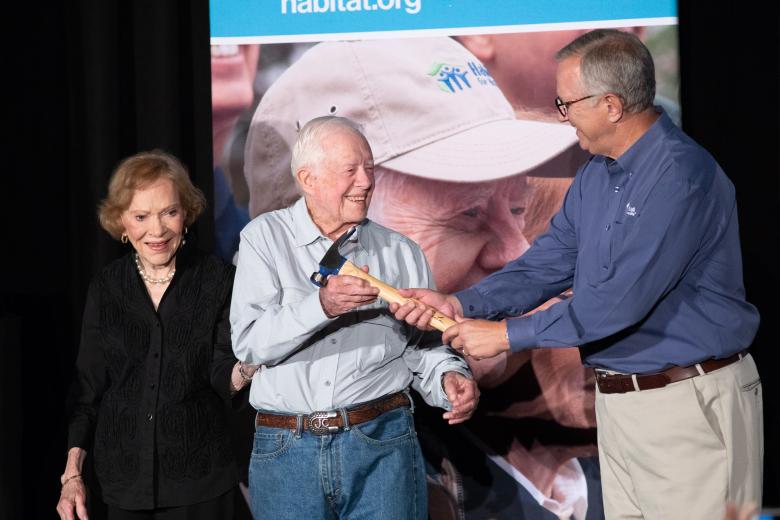 President and Mrs. Carterpass a hammer to Danny Herron, president and CEO of Habitat for Humanity of Greater Nashville. 