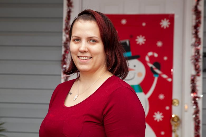 Merissa stands in front of her Habitat home.