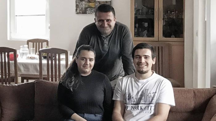 photo: family from Macedonia sitting on a sofa in their new apartment