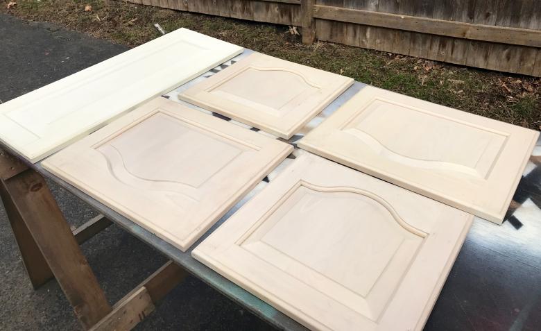 Five unpainted cabinet doors.