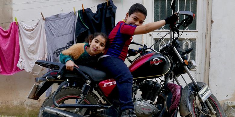 Photo: two children from sitting on a motor bike 