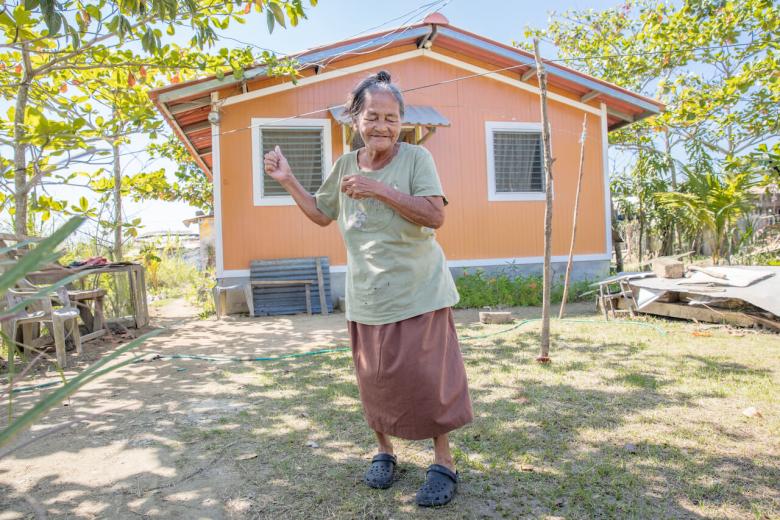 Photo: Estella from Honduras dancing in front of her newly built house