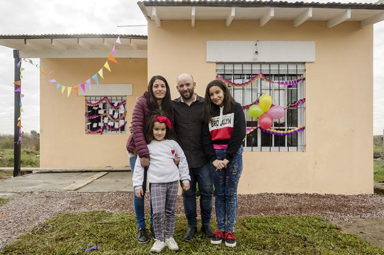 Carla and Rolando with their kids in front of their Habitat home.