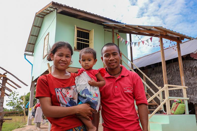 Chea and her husband Phlen with their child in front of their home completed during Cambodia Big Build 2019.