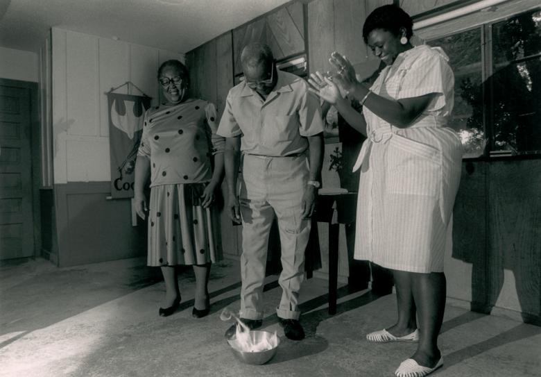 A family of Black homeowners burning their mortgage in a bowl.