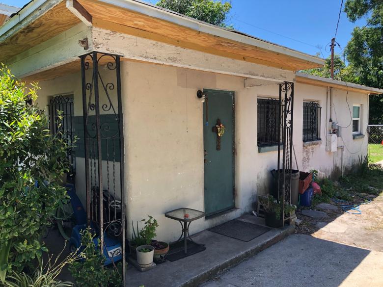 Ranch home with peeling paint and exposed wood.