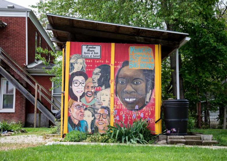 Mural of people of many skin tones painted on a garden shed for a community garden.