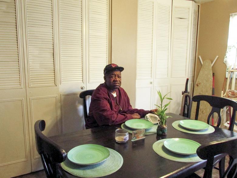 Freddie sits at a dining table made up with plates.